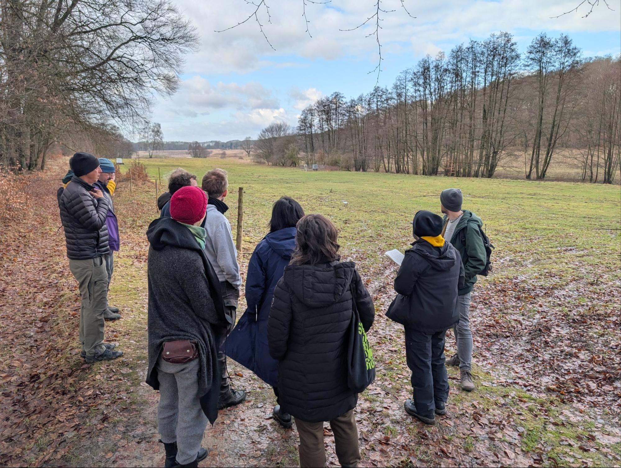 a dozen organizers from dweb and the department of decentralization survey the main field where campers will set up their tents.